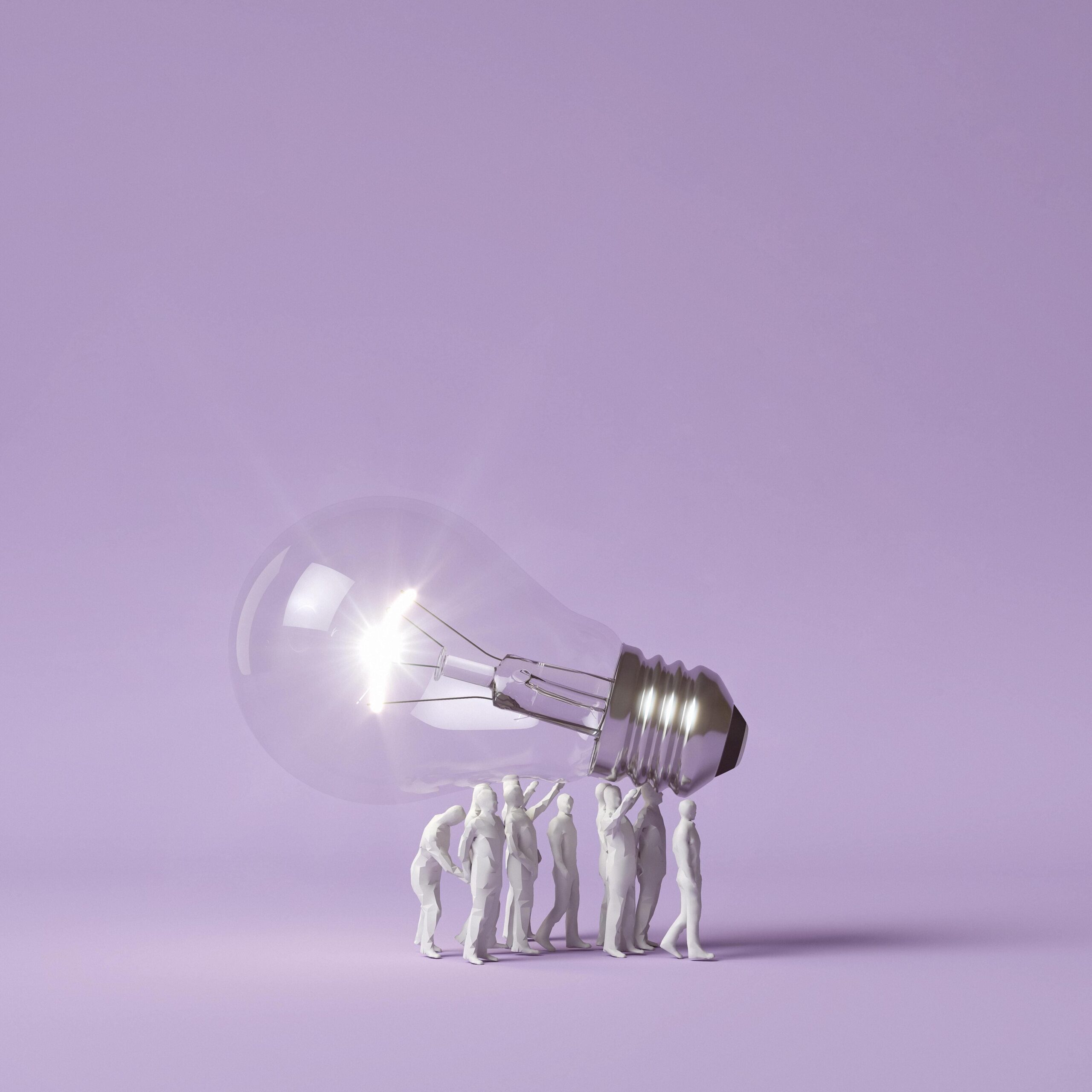 human-figurines-carrying-lit-lightbulb-as-idea-concept